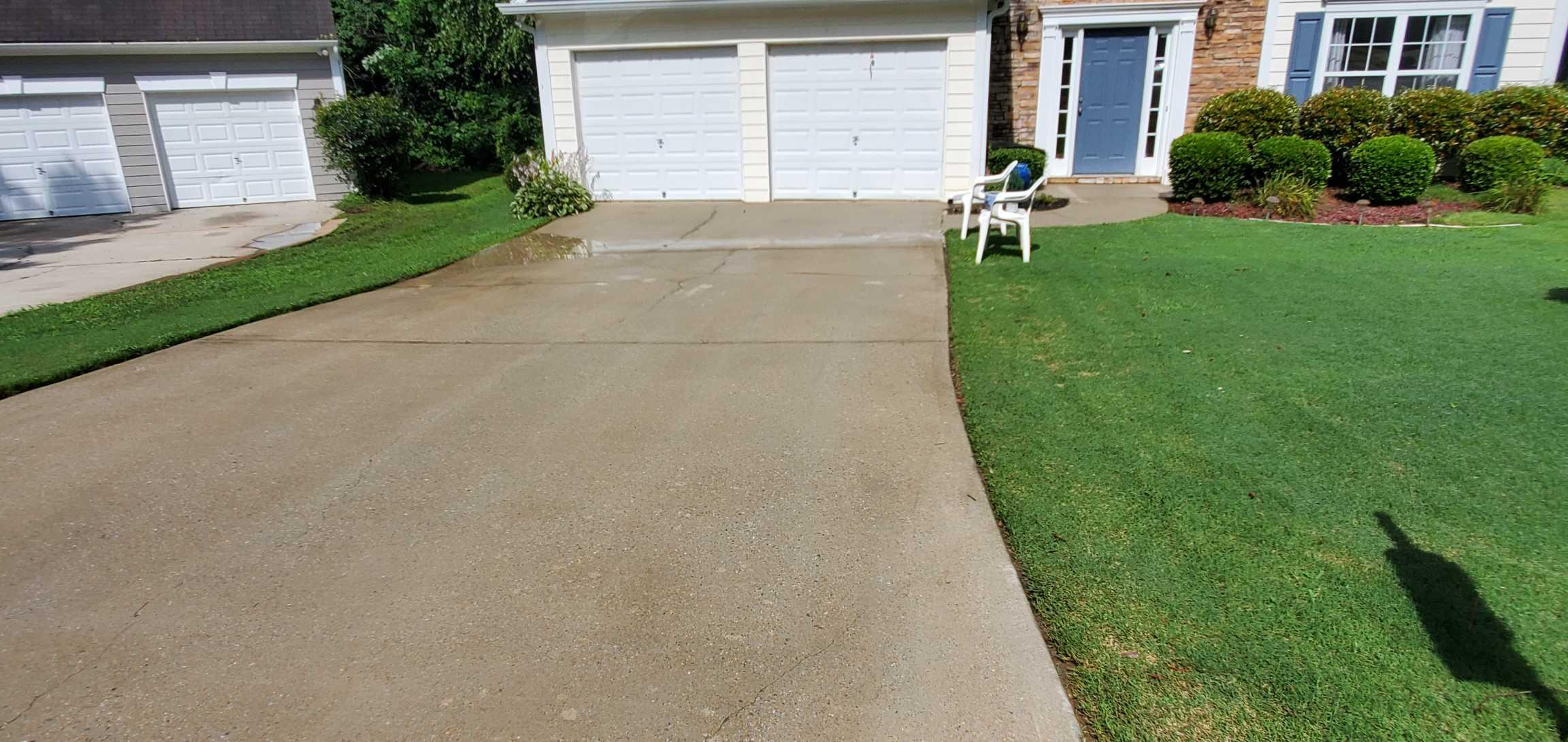 Same driveway restored to clean concrete after pressure washing